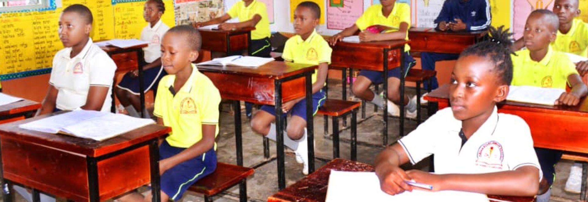 Attentive students of BoldStars Junior School listening to their teacher during a learning session.